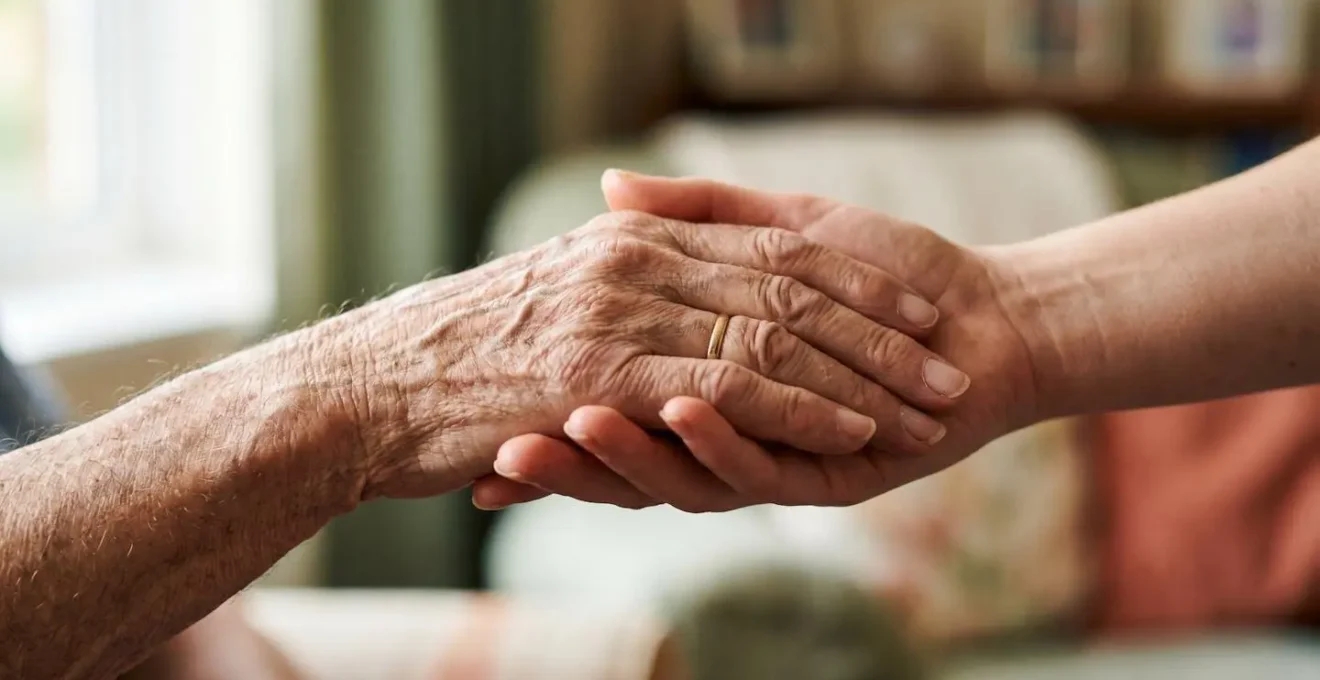 Close-up of gentle, reassuring interaction between a carer and elderly person showing trust and comfort