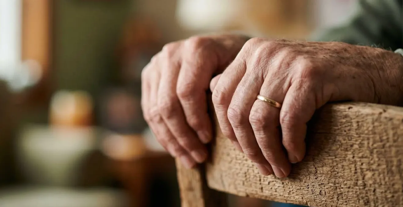 Close-up of senior hands gripping chair back with proper form during balance exercise